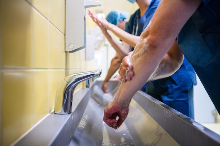 Group,of,surgeons,washing,their,hands,at,washbasin,in,hospital
